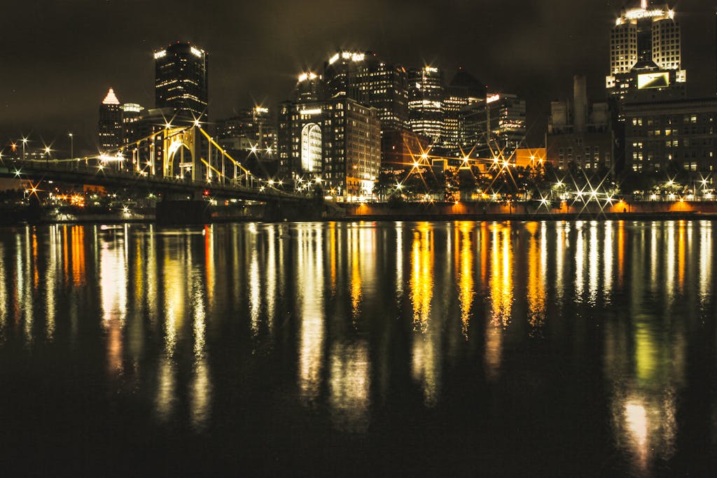 A breathtaking night view of a city skyline with reflections on the water.